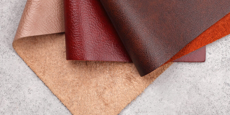 Different colors natural leather textures samples on gray stone background